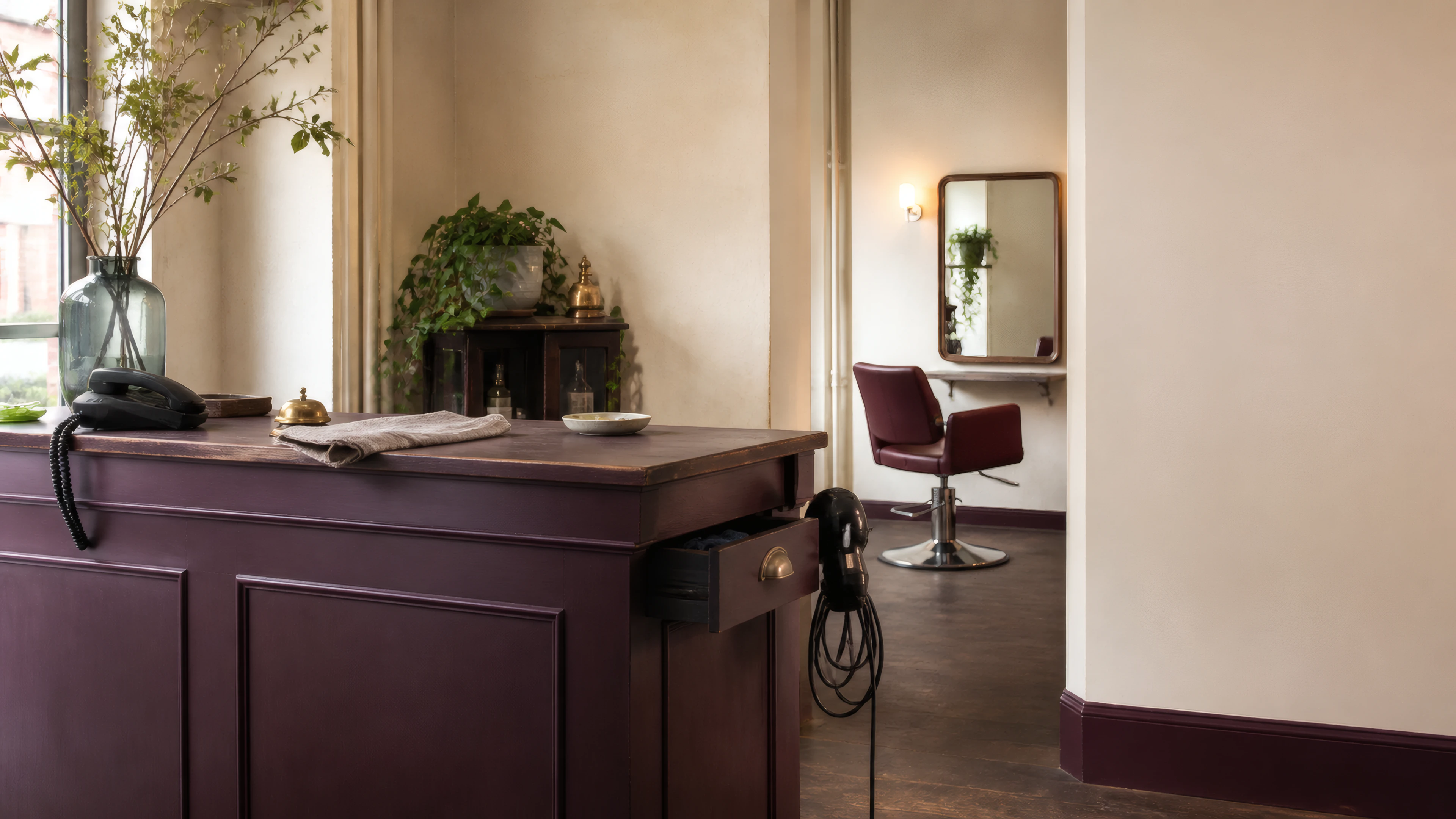 A working independent salon with its reception counter, phone, tools, chair, and mirror